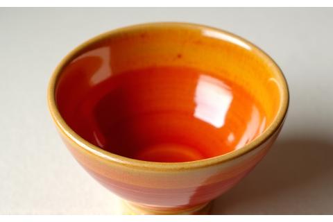 En håndlavet keramikskål i varme orange og røde nuancer, 'Morgenrøde'